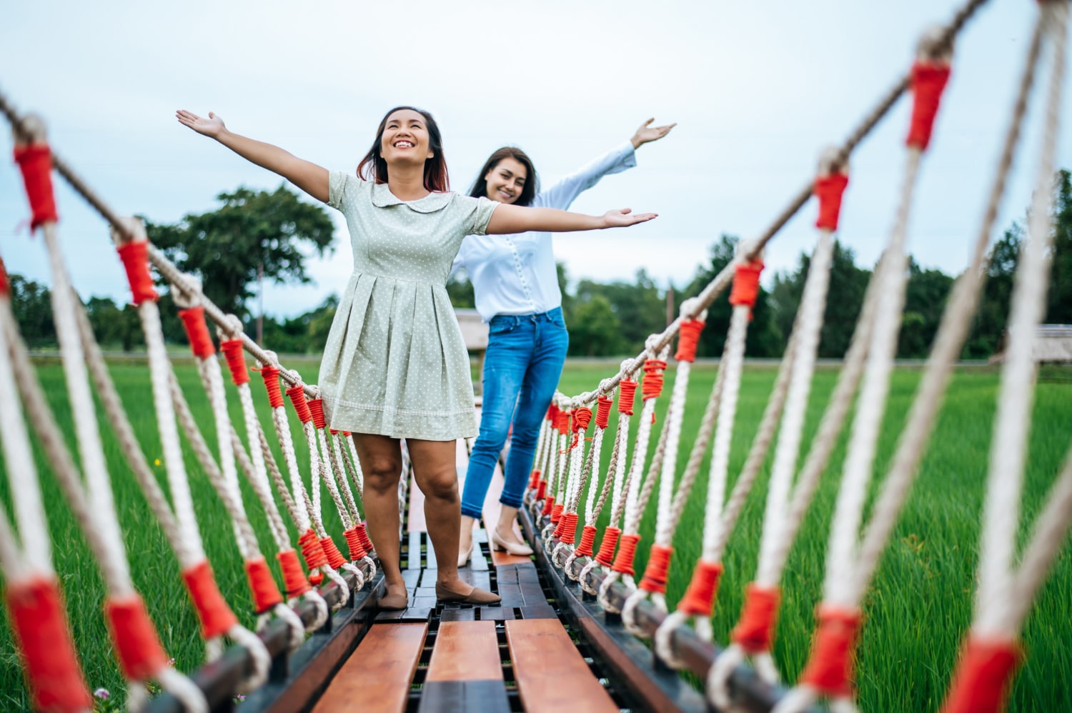Happy woman on a wooden bridge in a green meadow on a sunny day